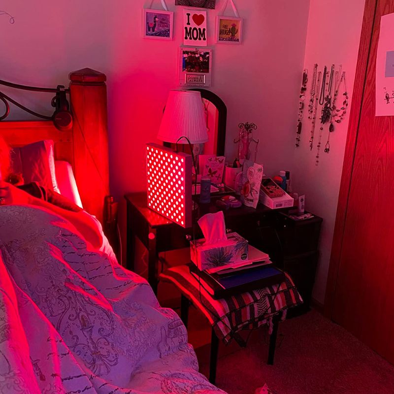 panel emitting red light on stand next to bed