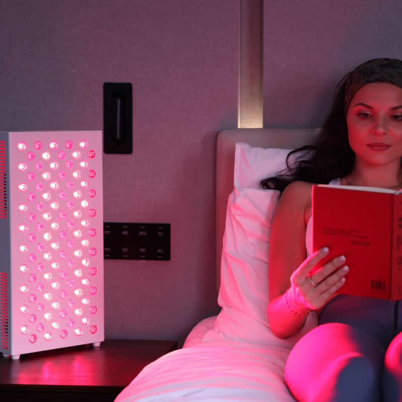 WomanReadingWithRedLightPanelOnBedside