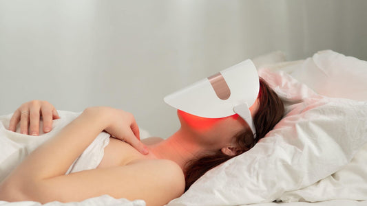 Photo of woman using red light therapy mask on face