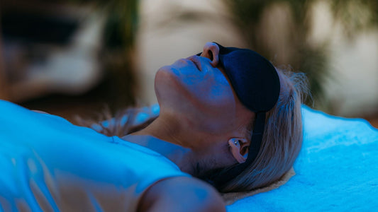 Woman laying down with sleeping mask on