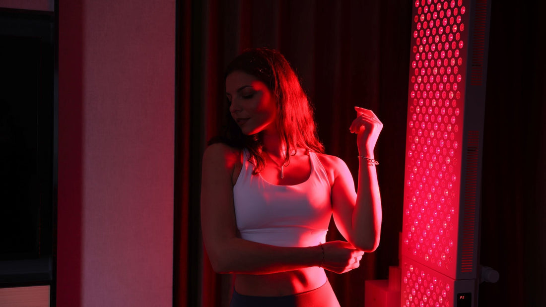 Woman with red light on her back, staring away from red light therapy panel