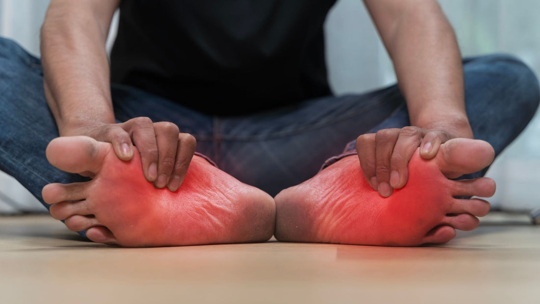 man holding feet with red inflammed look