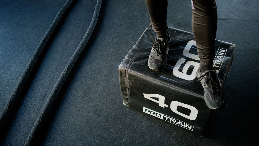 person standing on black box with rope in background
