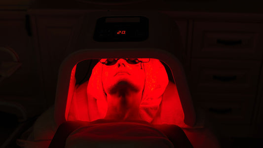 red light therapy dome device illuminating older womans face with red light