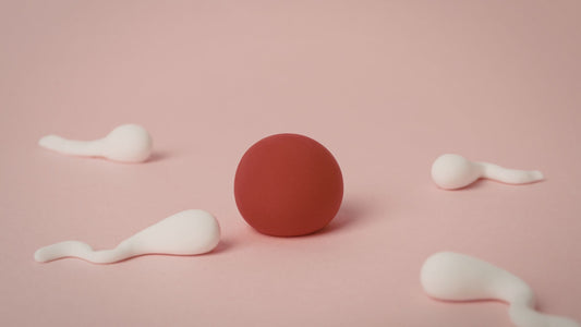 sperm going towards a red ball with a pink background