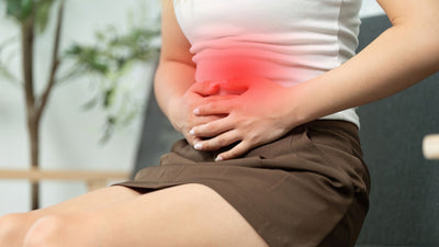 woman holding lower stomach area in pain with red flash