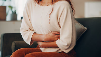 woman holding onto stomach in pain