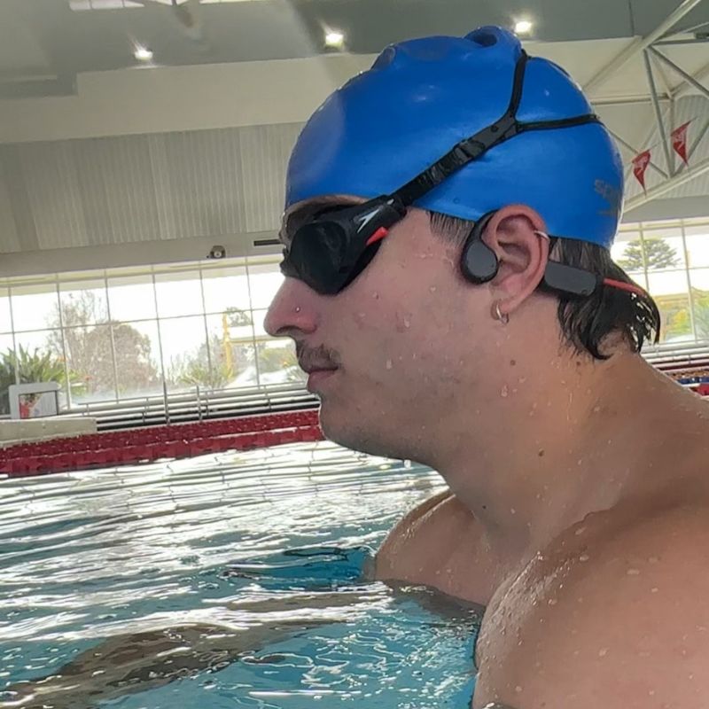 Man in water with IPX8 waterproof earbuds for swimming