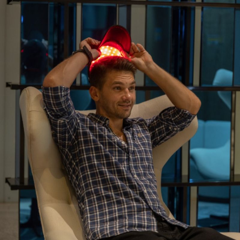 man using red light therapy cap