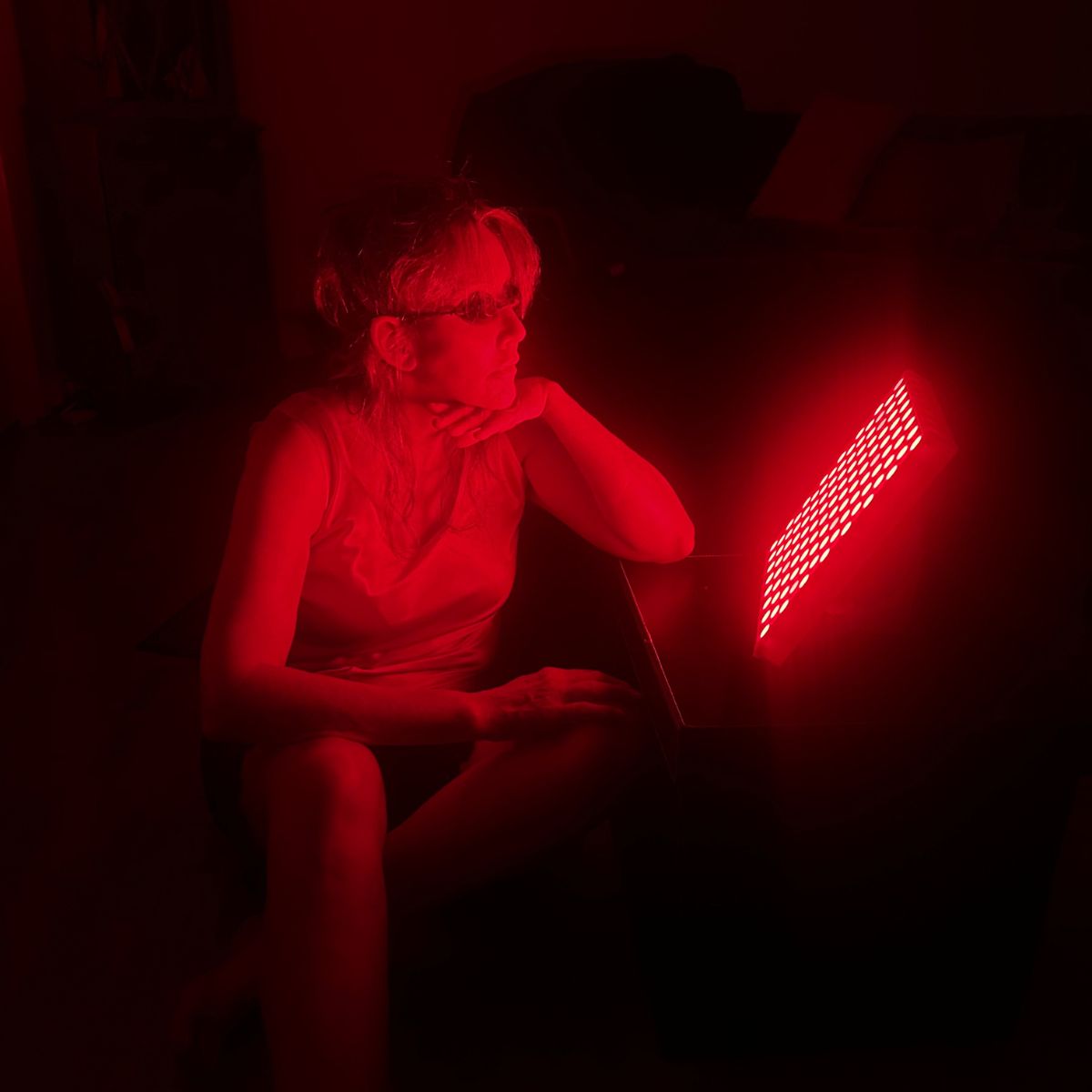Woman Using Red Light Therapy Panel with Goggles on