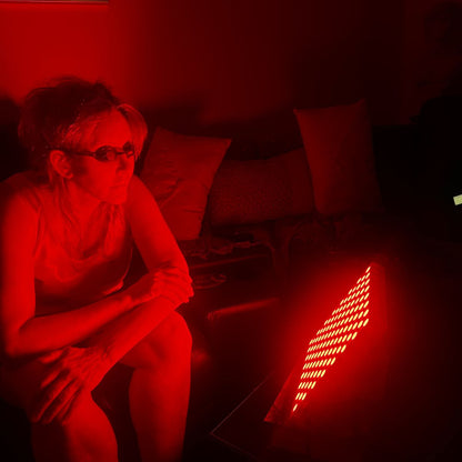 Woman Using Red Light Therapy Panel with Goggles on