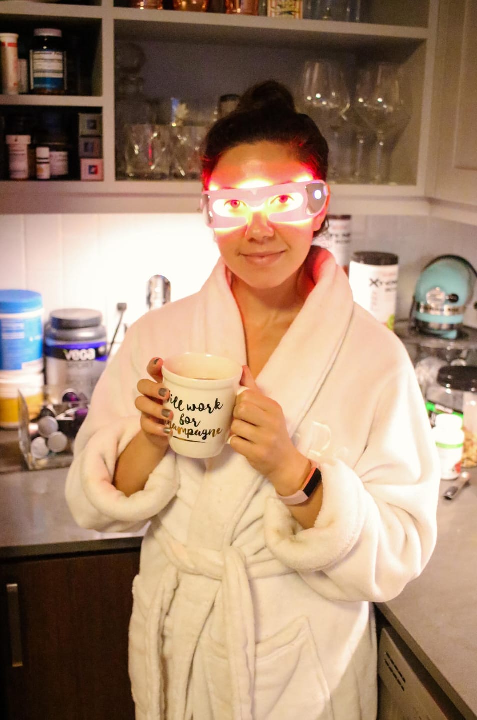 Woman holding mug with red light glasses on