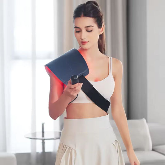 Woman_looking_at_controller_with_red_light_therapy_pad_on_her_shoulder