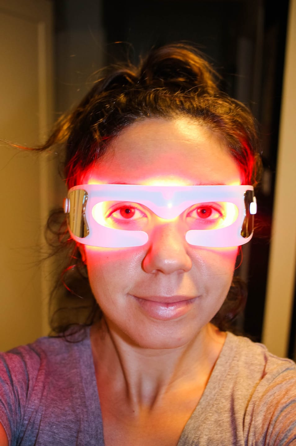 Woman taking selfie with red light glasses