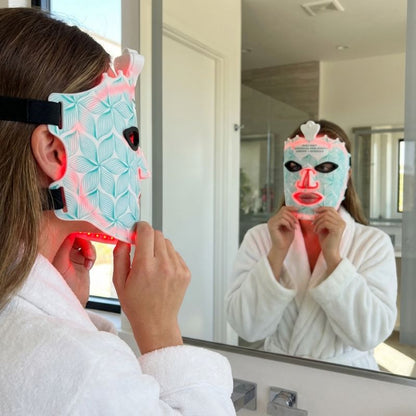 lady_staring_into_mirror_with_cyan_light_therapy_mask