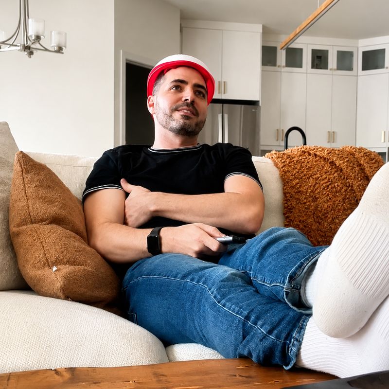 mansittingoncouchwhilewearinglaserlighttherapyhelmet