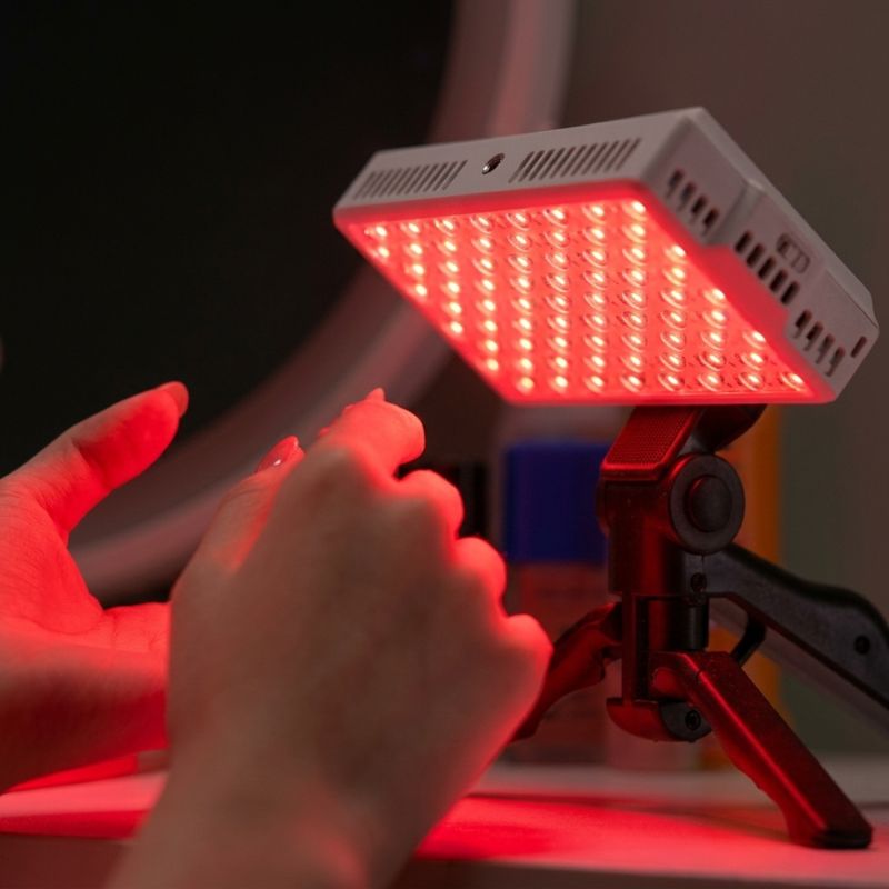 portableredlighttherapypanelontripodtargetinghands