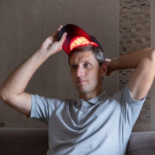red light therapy cap in use by man