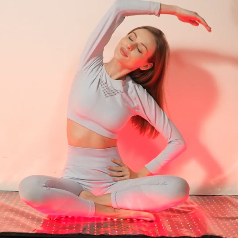 red light therapy mat with woman doing yoga on it