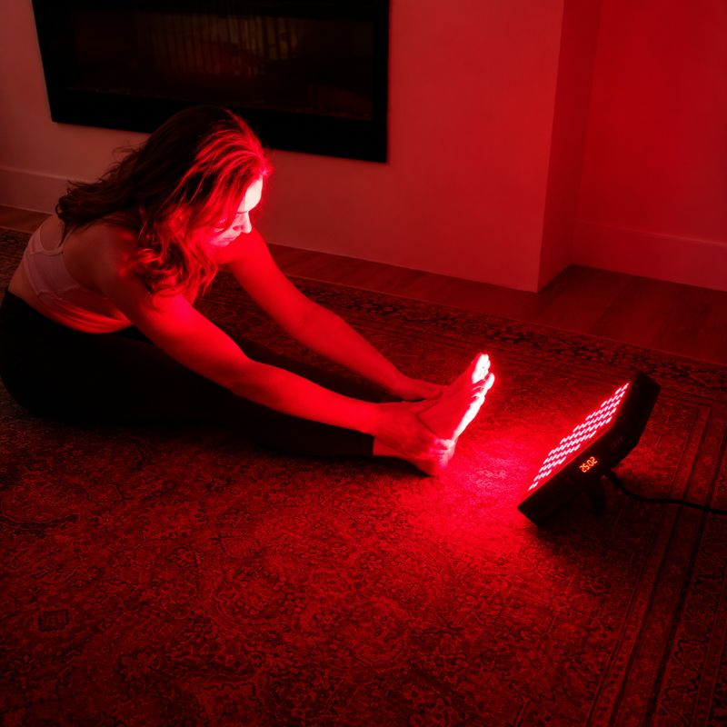 sr60redlighttherapypanelwithwomanstretchinginfrontofpanel