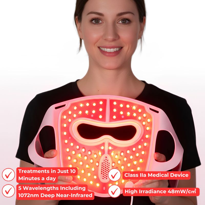 woman_holding_pink_led_light_therapy_mask_while_smiling