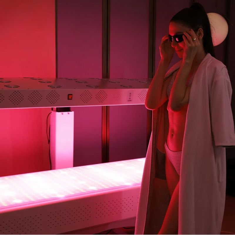 woman_outside_of_commercial_red_light_therapy_bed