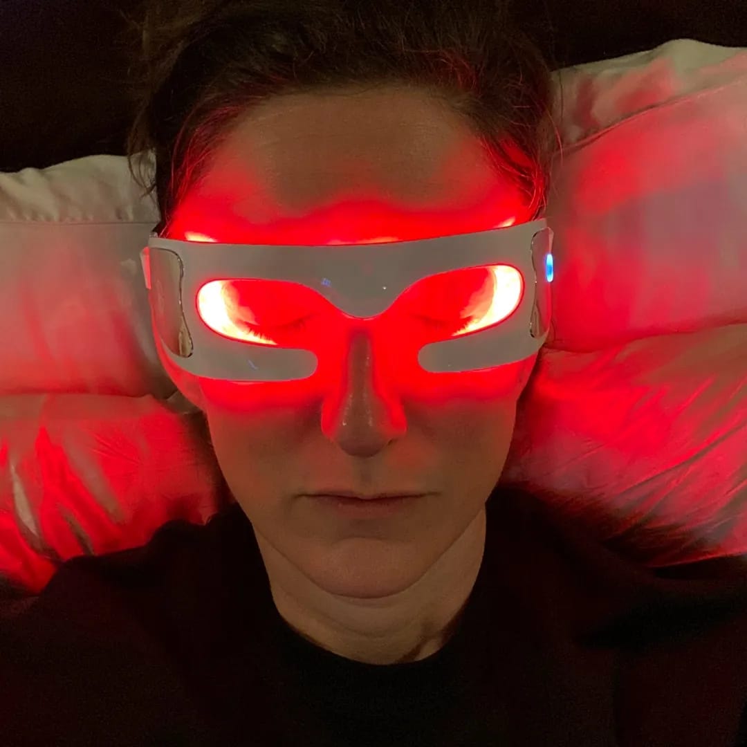 woman sleeping with red light therapy glasses on