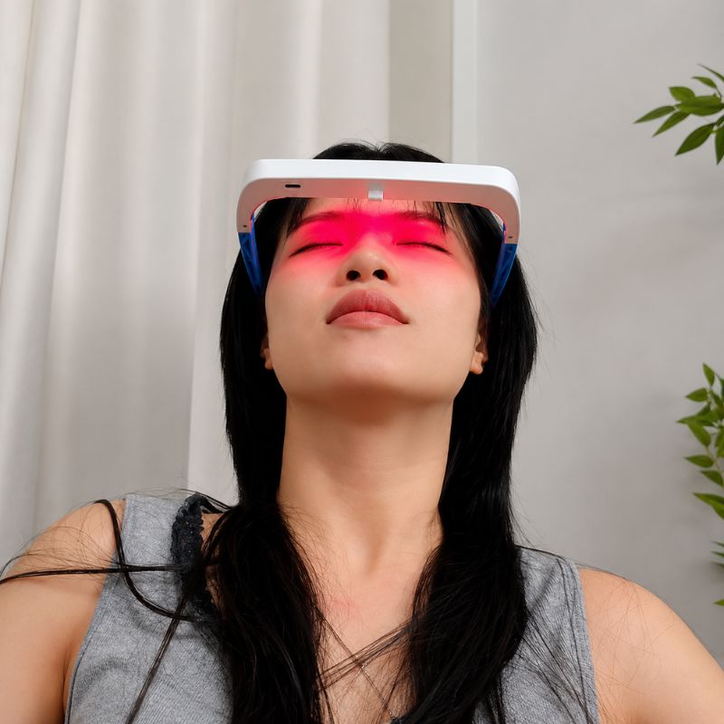 womanlayinginchairrelaxingwithredlighttherapyglasseson2