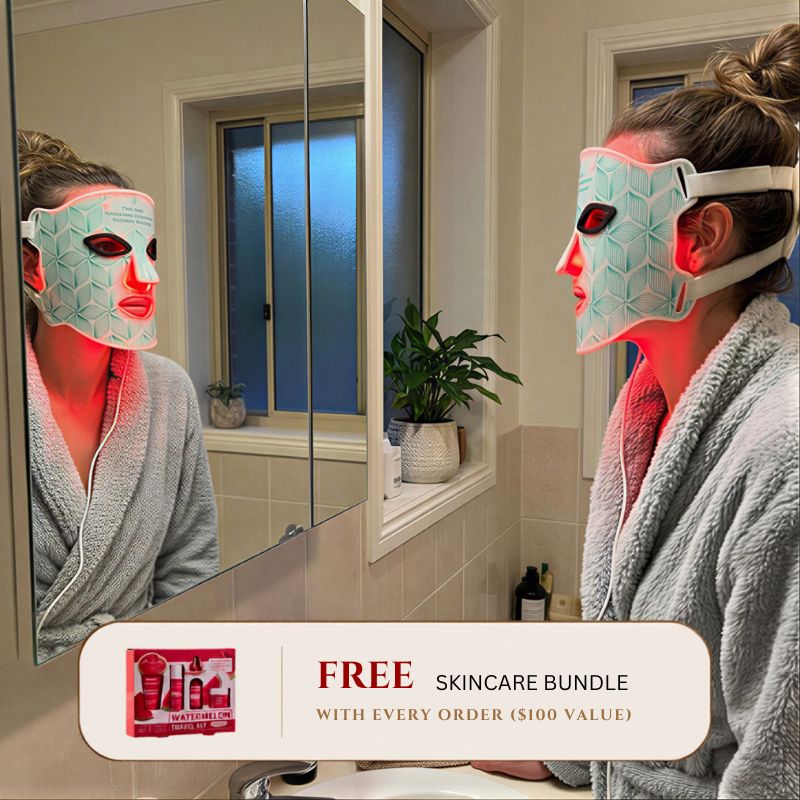 woman staring into mirror while wearing led light therapy mask