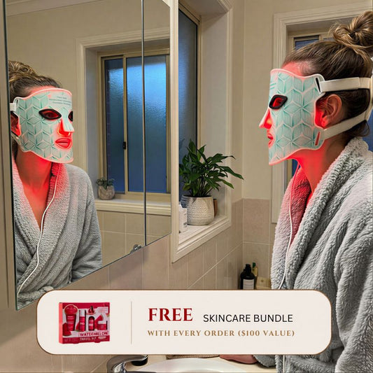 woman staring into mirror while wearing led light therapy mask