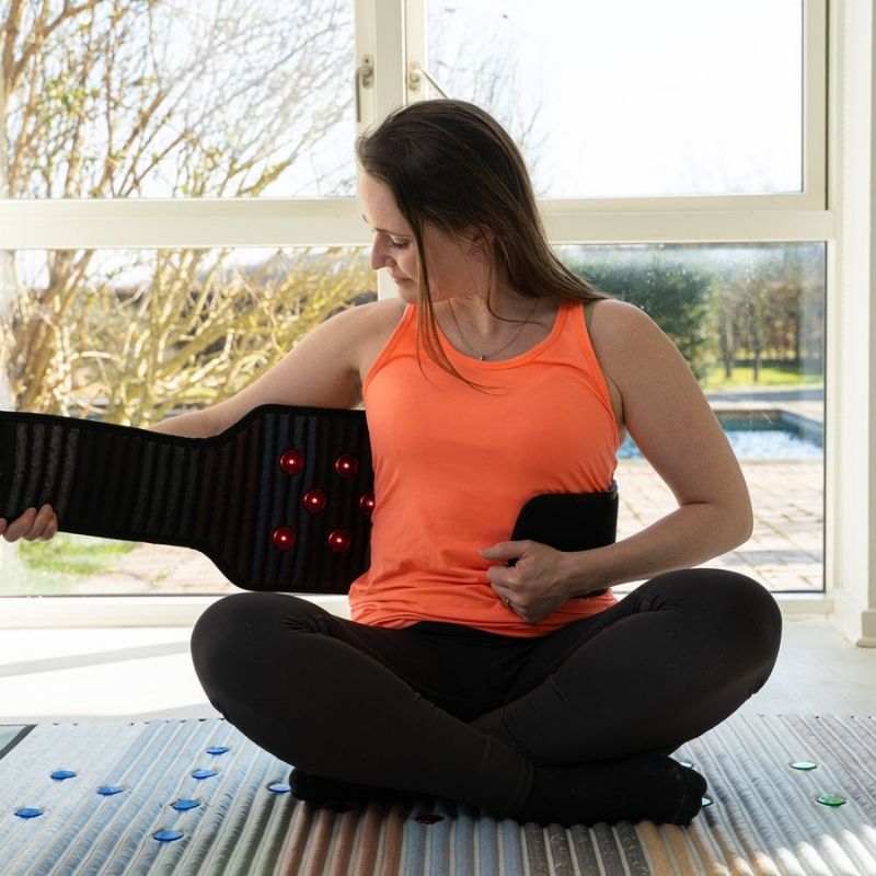 womanstrappingonWearablePemfBeltwithRedLightTherapy_ab891b24-2899-4623-b42b-ac993337c845